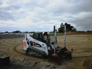 Bobcat spreading sand with laser leveler